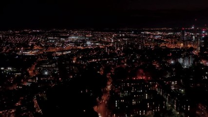 Night time aerial footage of the Leeds City Centre taken at night with a drone showing the West Yorkshire city centre all lit up with lights in the evening.