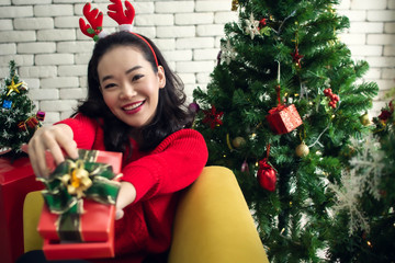 Woman wearing red sweater and sitting on sofa in christmas party