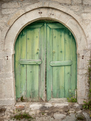 Fototapeta na wymiar wooden doors with weathered green paint in traditional village of Kalarites in the Tzoumerka region, Greece