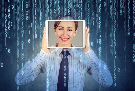 Happy woman holding tablet with her face displayed on a screen
