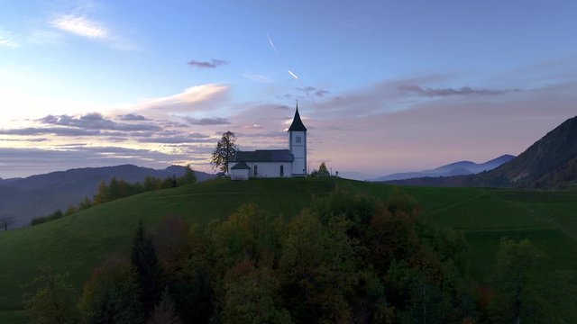 Aerial view of landscape of church of St. Primoz near Jamnik, Slovenia and Julian Alps at background