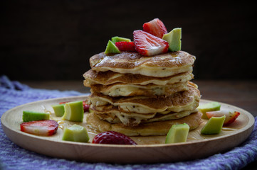 pancake strawberry avocado fruit and honey syrup sweeet dessert homemade and ready to eat on wood table.