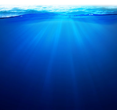 Undersea background Light rays under deep water with wave surface above