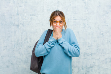 young student woman happy and excited, surprised and amazed covering mouth with hands, giggling...