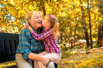 Grandmother and granddaughter enjoying while spending time together in autumn park