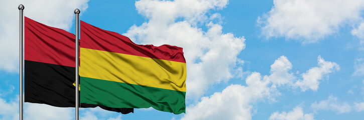 Angola and Bolivia flag waving in the wind against white cloudy blue sky together. Diplomacy concept, international relations.