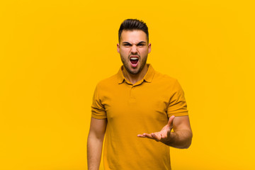 young hispanic man looking angry, annoyed and frustrated screaming wtf or what‚Äôs wrong with...