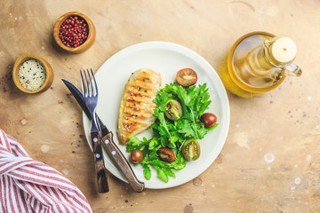 Chicken fillet salad with tomato and arugula leaves.