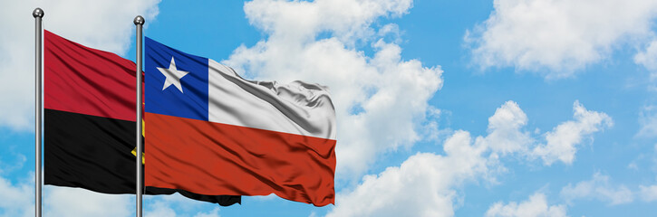 Angola and Chile flag waving in the wind against white cloudy blue sky together. Diplomacy concept, international relations.