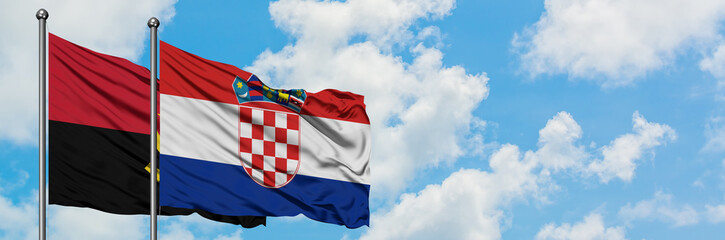 Angola and Croatia flag waving in the wind against white cloudy blue sky together. Diplomacy concept, international relations.