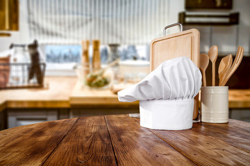 Kitchen table top with kitchen accessorries and empty space for you products or decorations. Blurred kitchen background.
