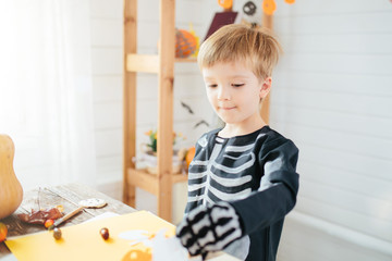 Halloween party. Little boy in a skeleton costume is ready to celebrate Halloween. Boy in a halloween dress-up room.