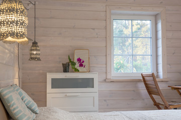 Bright bedroom interior in a wooden house in a Scandinavian style.