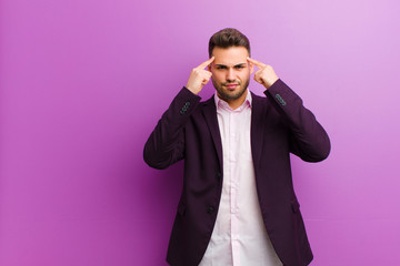 young hispanic man with a serious and concentrated look, brainstorming and thinking about a...