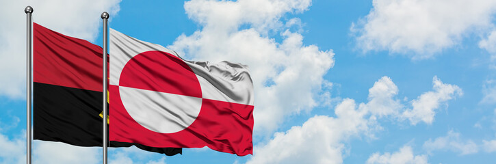 Angola and Greenland flag waving in the wind against white cloudy blue sky together. Diplomacy concept, international relations.