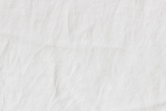 White crinkle linen texture. Closeup of fabric, tablecloth or bed linen. Light empty copy space.