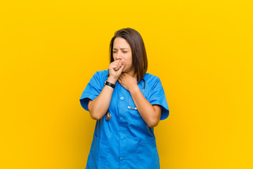 feeling ill with a sore throat and flu symptoms, coughing with mouth covered isolated against...
