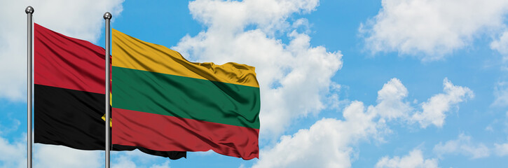 Angola and Lithuania flag waving in the wind against white cloudy blue sky together. Diplomacy concept, international relations.