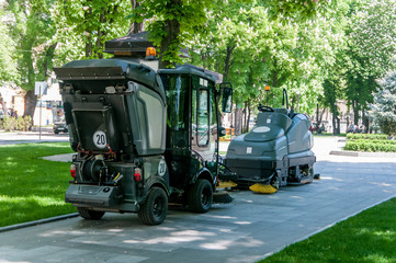 two sidewalk cleaning machines in the park