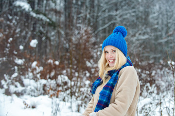 Fototapeta na wymiar Winter mood. Beautiful blonde girl in a blue warm hat. Winter fashion.