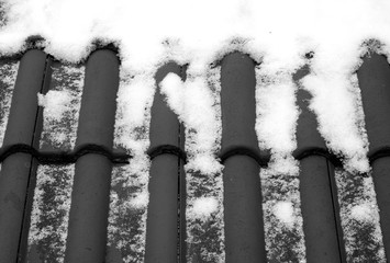 Snow on roof in black and white.