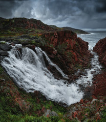 Tundra nature colorful landscape at Kola Peninsula in the autumn. Waterfall near Teriberka village at Murmansk Region in Northern Russia