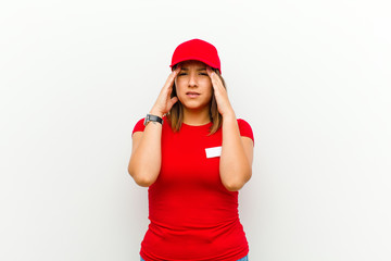 delivery woman looking stressed and frustrated, working under pressure with a headache and troubled...