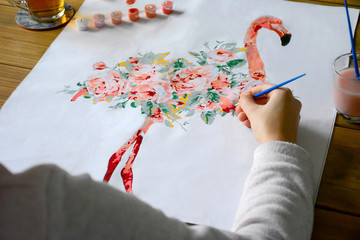 Young woman is painting a flamingo. DIY.