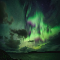 Northern Lights, Aurora Borealis in Kola Peninsula at night sky illuminated green. Murmansk region, Russia