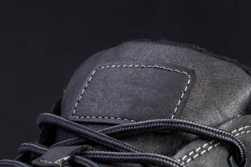 Part of a leather boot close-up. A fragment of the texture of leather shoes.