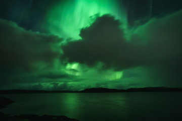 Fototapeta na wymiar Northern Lights, Aurora Borealis in Kola Peninsula at night sky illuminated green. Murmansk region, Russia