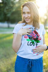 Portrait of a beautiful young modern woman with brown hair smiling and having fun outdoor in the summer, park with warm backlight at sunset