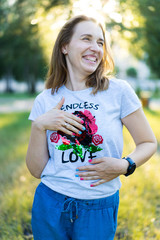Portrait of a beautiful young modern woman with brown hair smiling and having fun outdoor in the summer, park with warm backlight at sunset