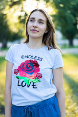 Portrait of a beautiful young modern woman with brown hair smiling and having fun outdoor in the summer, park with warm backlight at sunset