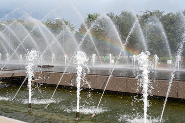 rainbow from the spray of fountain on the background of the Park