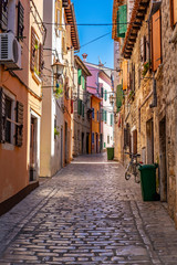 Fototapeta na wymiar Narrow street with colourful building facades in romantic Town of Rovinj, Istra, Croatia