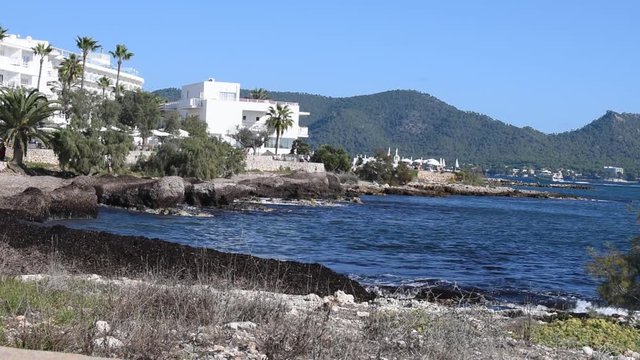 Seafront between Cala Bona and Cala Millor on a warm and sunny day in October with the Glass Bottom Boat heading towards the marina at Cala Bona.