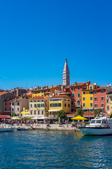 Fototapeta premium Panoramiczny widok na port i domy z kolorowymi fasadami w mieście Rovinj w słoneczny letni dzień, Istra, Chorwacja
