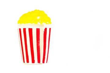 Toy bright striped glass with yellow popcorn. American culture concept.Popcorn in a red-white box