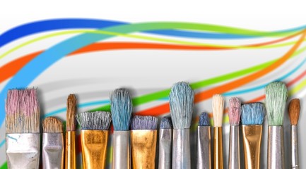 Row of artist paint brushes on background