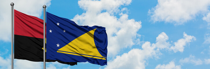 Angola and Tokelau flag waving in the wind against white cloudy blue sky together. Diplomacy concept, international relations.