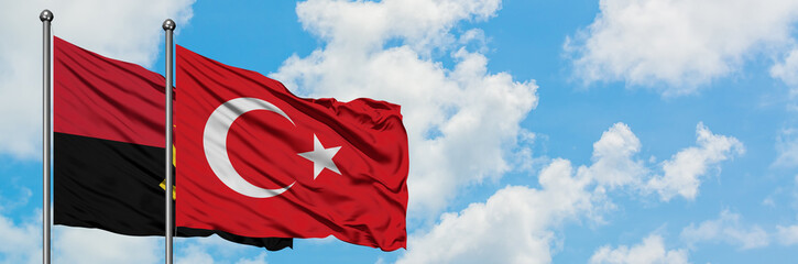 Angola and Turkey flag waving in the wind against white cloudy blue sky together. Diplomacy...