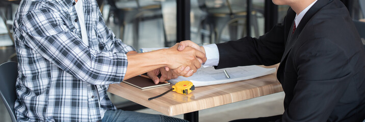 Professional businessman shaking hands with builder on construction site, handshake concept.