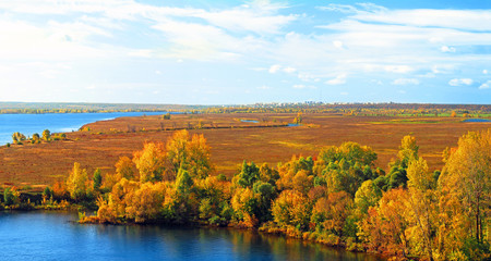 Autumn sunny day, countryside, beautiful nature landscape, river, aerial panoramic view, horizon, pastures. City in the background