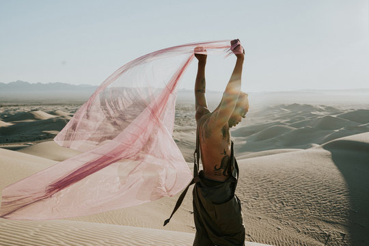 Side view of man holding net in desert