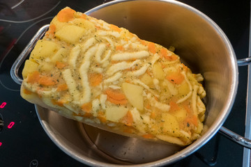 Frozen potato soup in a saucepan on the stove