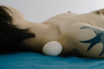 Woman with egg near her shoulder