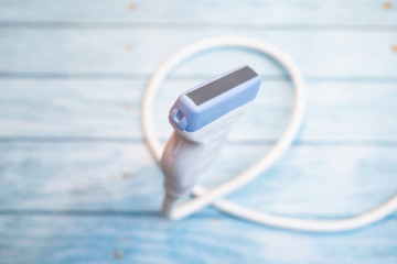 Ultrasound probe floating in air on wooden background