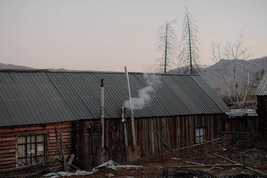 Log house with chimney emitting smoke