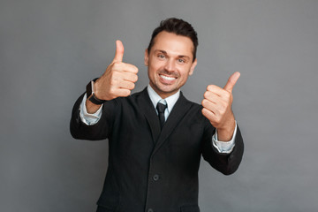 Businessman studio standing isolated on grey thumbs up smiling toothy